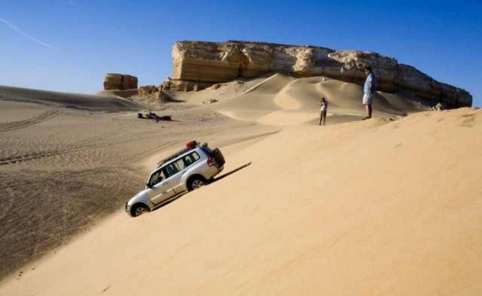 4x4 jeep driving over sand dunes in the Western Desert near the White Desert