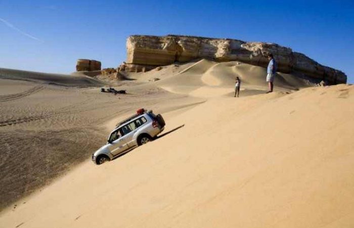 4x4 jeep driving over sand dunes in the Western Desert near the White Desert