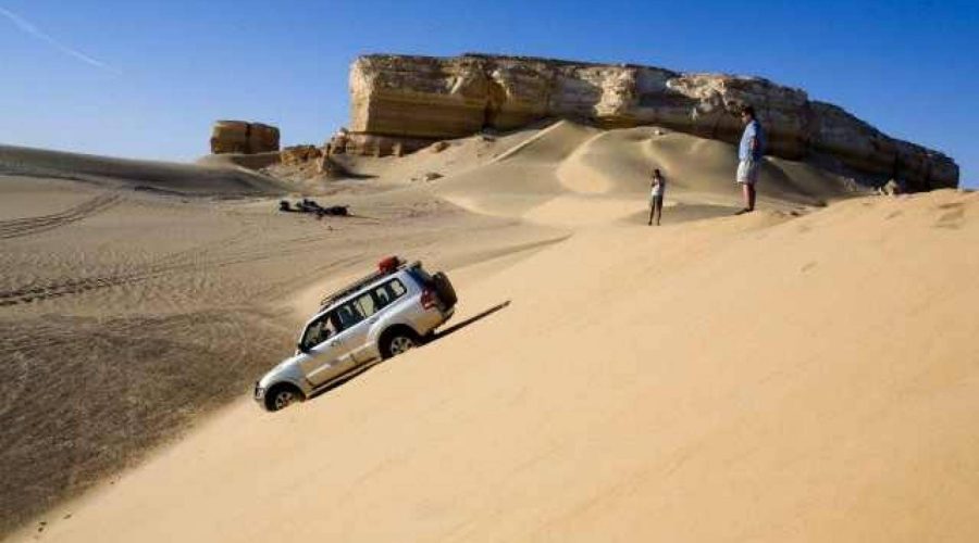 4x4 jeep driving over sand dunes in the Western Desert near the White Desert