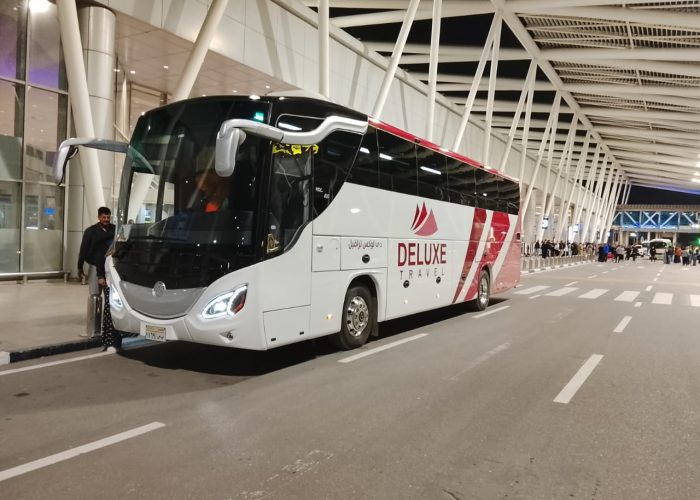 Deluxe Travel Egypt coach at an airport terminal for a group airport transfer