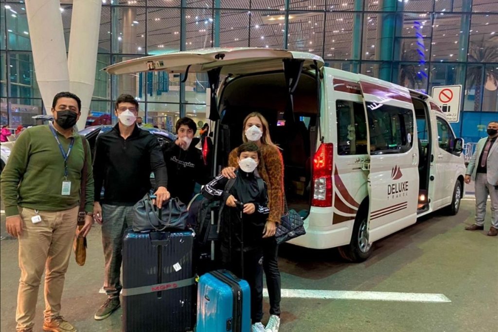 Guests with luggage and the Deluxe Travel Egypt van at Cairo Airport