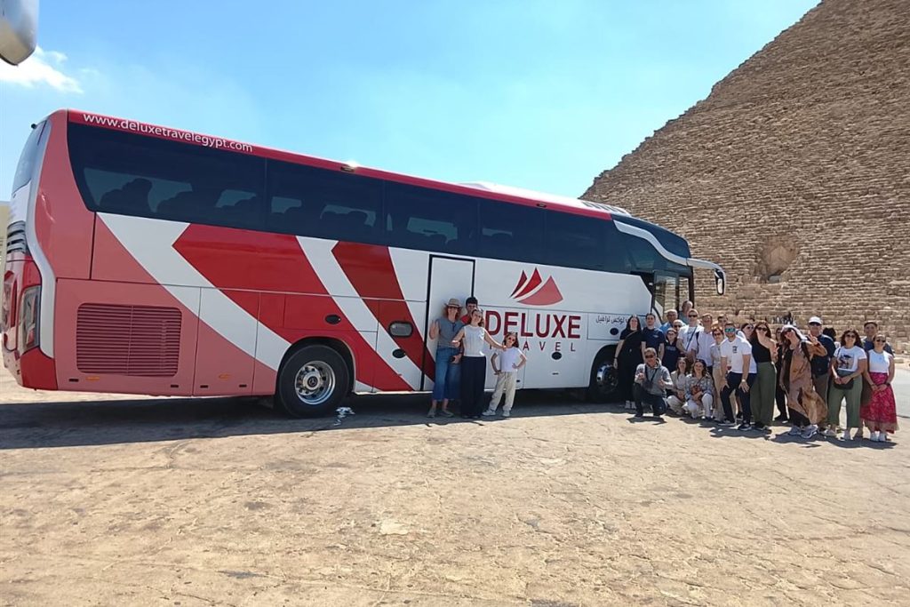 Group of guests with the Deluxe Travel Egypt coach at the Pyramids