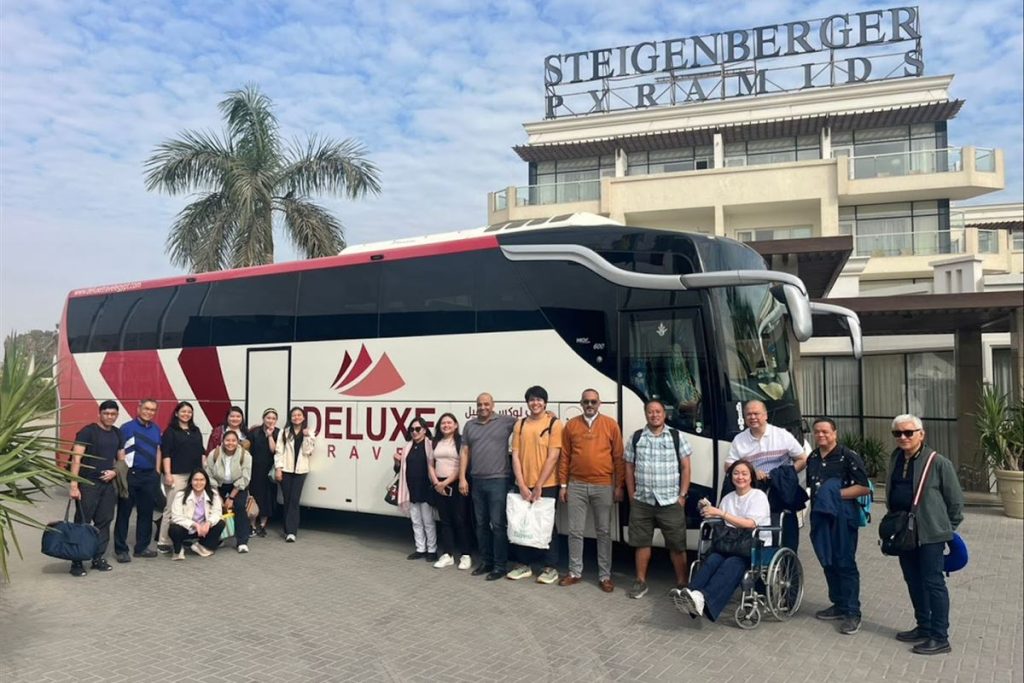 Group with the Deluxe Travel Egypt coach outside a hotel