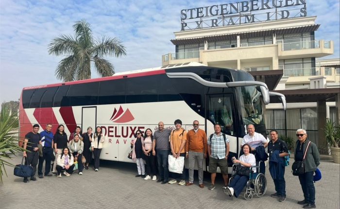 Group with the Deluxe Travel Egypt coach outside a hotel