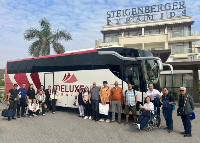 Group with the Deluxe Travel Egypt coach outside a hotel