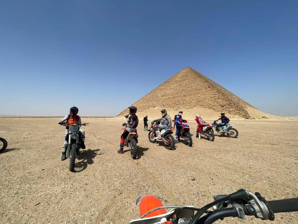 Riders on dirt bikes and ATVs crossing the desert near Saqqara