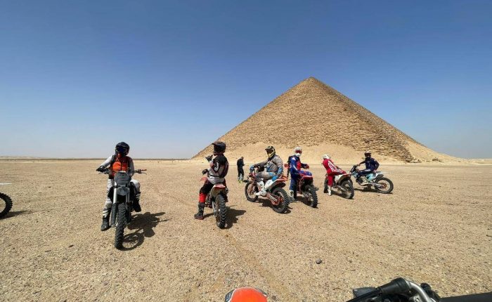 Riders on dirt bikes and ATVs crossing the desert near Saqqara