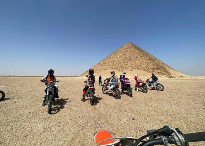 Riders on dirt bikes and ATVs crossing the desert near Saqqara