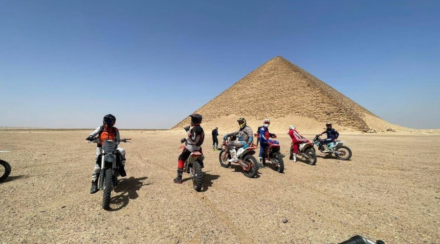 Riders on dirt bikes and ATVs crossing the desert near Saqqara