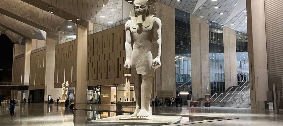Colossal royal statues lining the Grand Staircase of the Grand Egyptian Museum in Giza