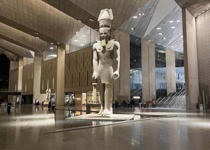 Colossal royal statues lining the Grand Staircase of the Grand Egyptian Museum in Giza