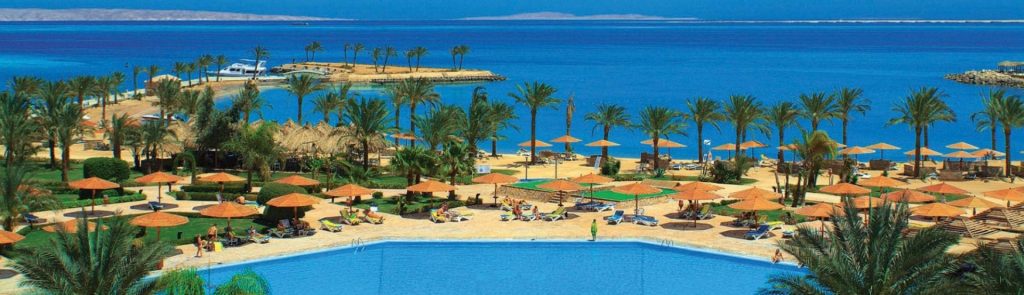 Palm-lined pool and sandy beach at a resort in Hurghada on the Red Sea