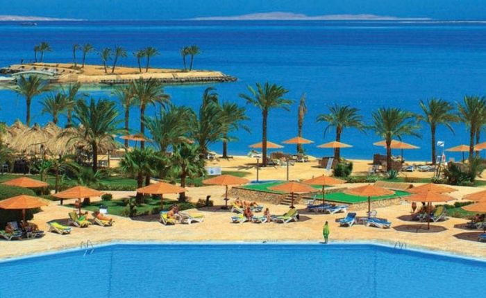 Palm-lined pool and sandy beach at a resort in Hurghada on the Red Sea