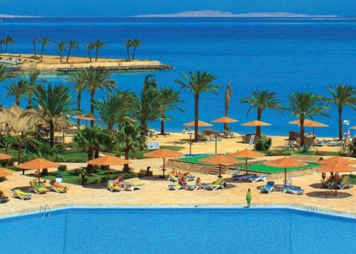 Palm-lined pool and sandy beach at a resort in Hurghada on the Red Sea