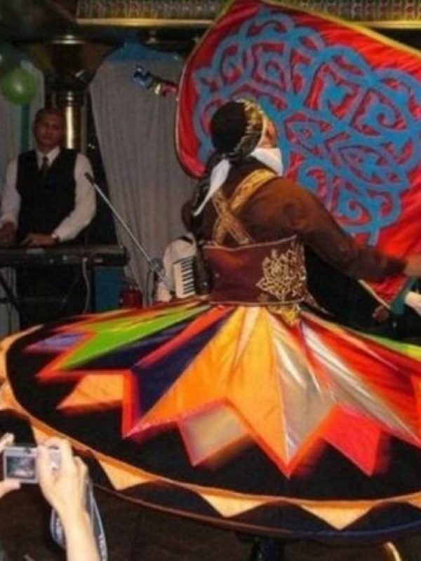 Tanoura dancer spinning in a colourful skirt during a Nile dinner cruise show in Cairo