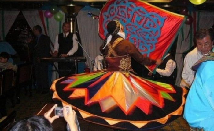 Tanoura dancer spinning in a colourful skirt during a Nile dinner cruise show in Cairo