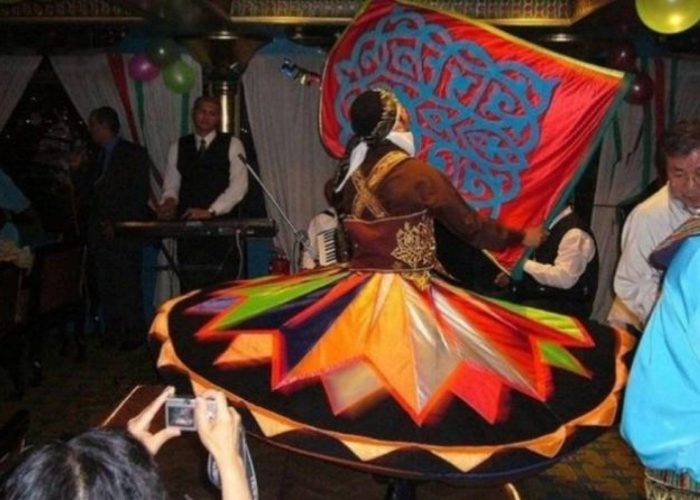 Tanoura dancer spinning in a colourful skirt during a Nile dinner cruise show in Cairo