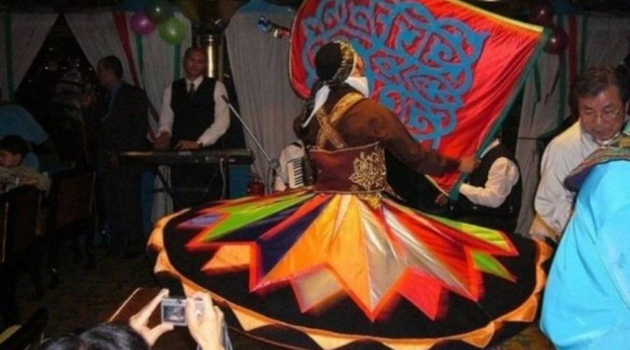 Tanoura dancer spinning in a colourful skirt during a Nile dinner cruise show in Cairo