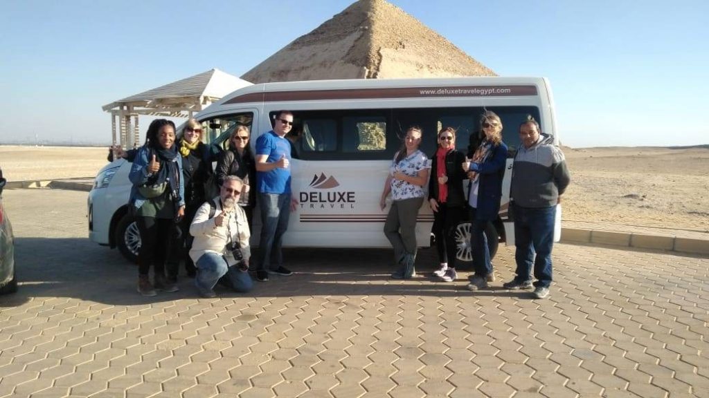 Group of travellers standing beside a Deluxe Travel Egypt private van